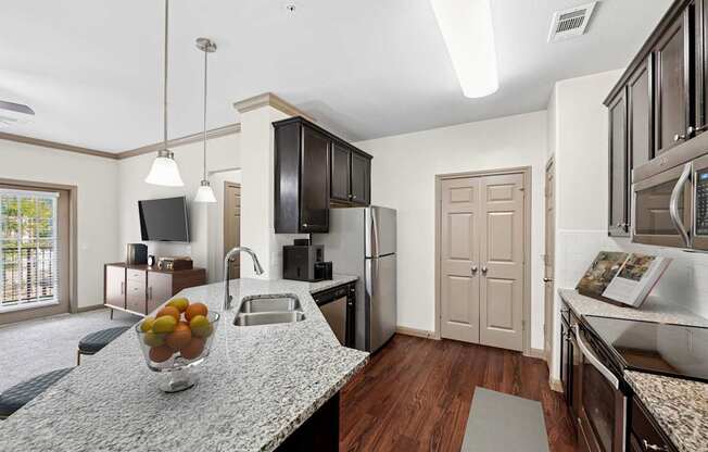 A kitchen with a bowl of fruit on the counter.