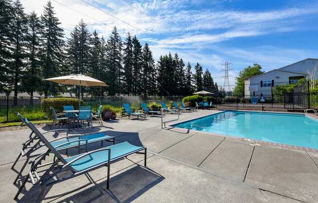 Community Swimming Pool with Pool Furniture at Landings at Morrison Apartments located in Gresham, OR.