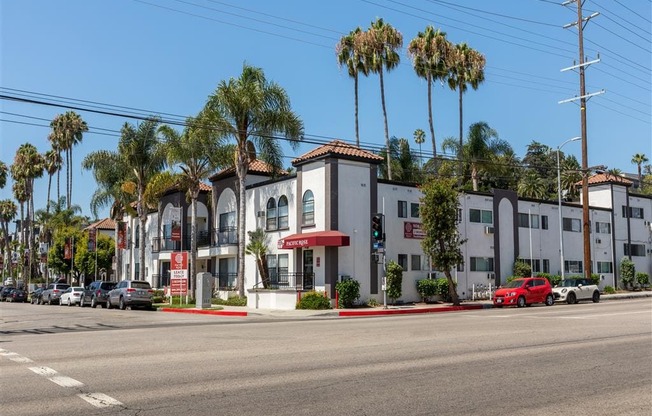 a row of apartment buildings with palm trees in the background at Pacific Rose, Los Angeles, CA 90034