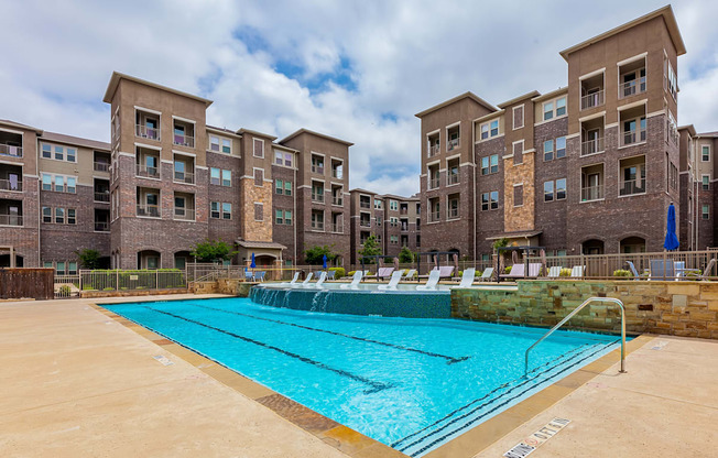 A swimming pool in front of apartment buildings.