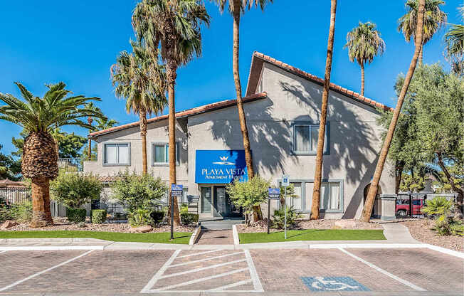 A building with a blue sign that says "PLAYA VIEJO" is surrounded by palm trees.