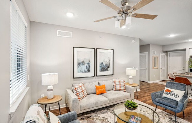 a living room with a couch and a ceiling fan