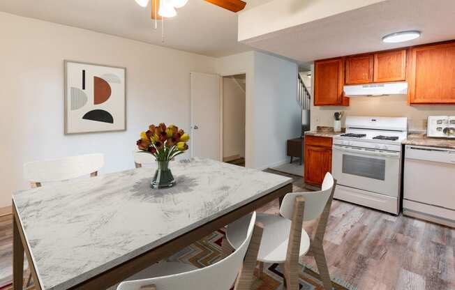 a kitchen with white appliances and a table with chairs