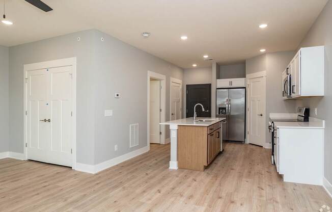 A kitchen with white cabinets and a wooden island.