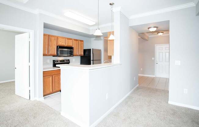 A kitchen with white walls and wooden cabinets.