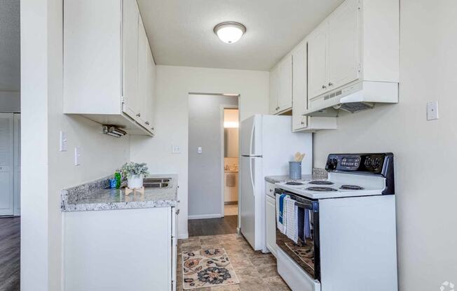 a kitchen with white cabinets and a stove and a refrigerator