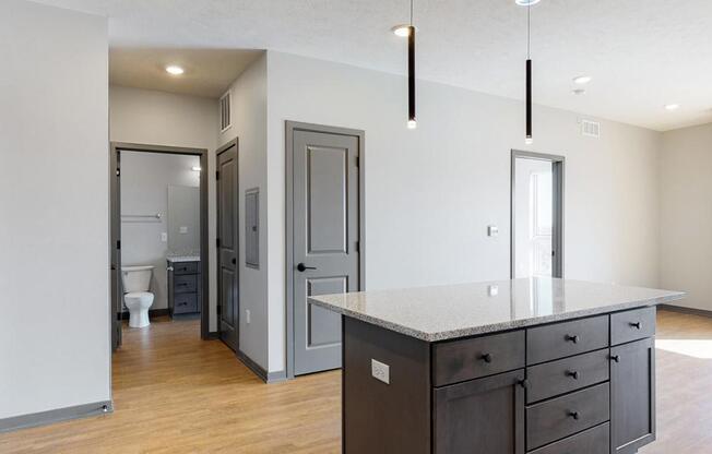 View of kitchen island and hallway leading to the bathroom in the Bliss floor plan at Haven at Uptown in Lincoln, NE