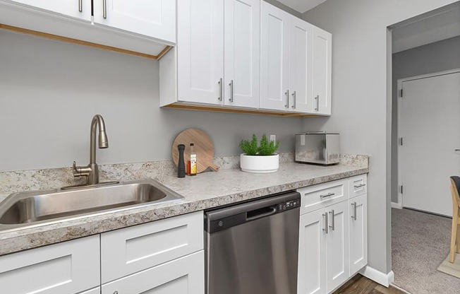 Model Kitchen with White Cabinets and Wood-Style Flooring at Stone Ends Apartments in Stoughton, MA.