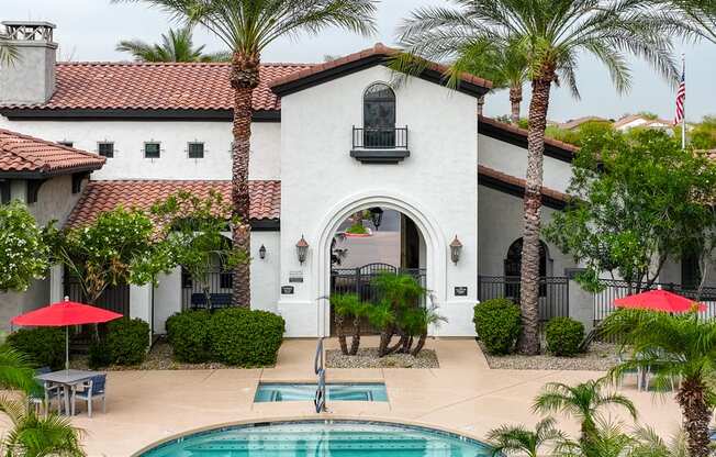 a house with a swimming pool and palm trees