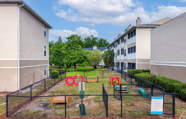 a fenced in play area in front of some apartments