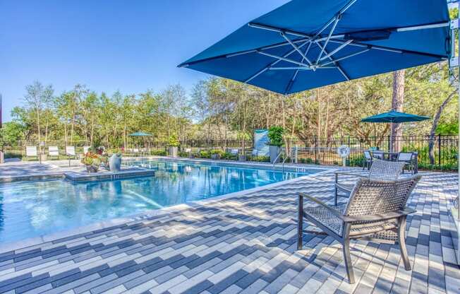 a swimming pool with chairs and umbrellas next to it