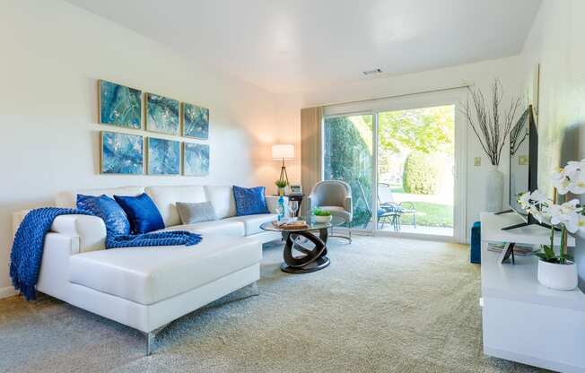 a living room with a white couch and blue pillows