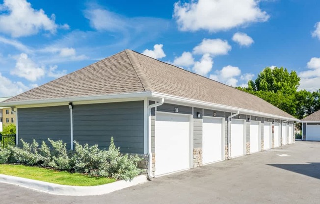 A building with a grey roof and white garage doors at Mode at Melbourne, LLC Apartments, Melbourne, 32901