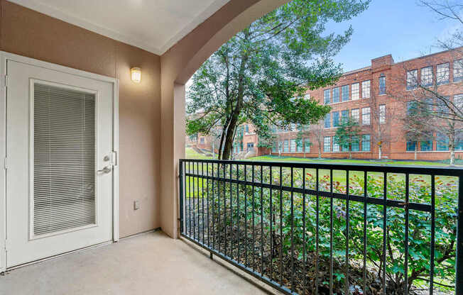 A balcony with a black railing and a view of a brick building.