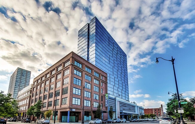 a tall building on a city street under a cloudy sky