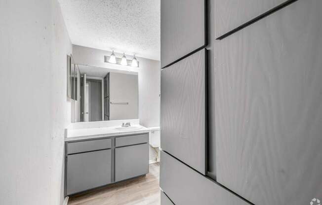 A bathroom with a sink and a mirror.