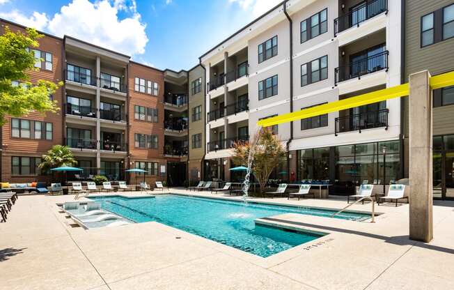 a swimming pool in front of an apartment building