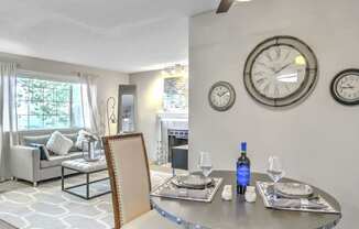 A dining room with a table set for two and a ceiling fan.