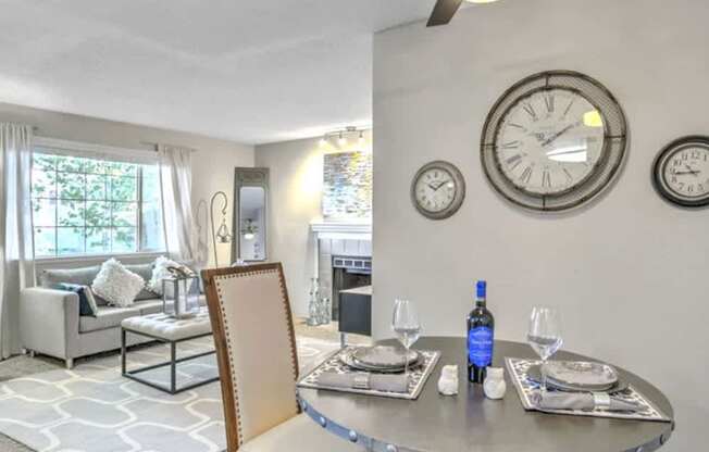 A dining room with a table set for two and a ceiling fan.