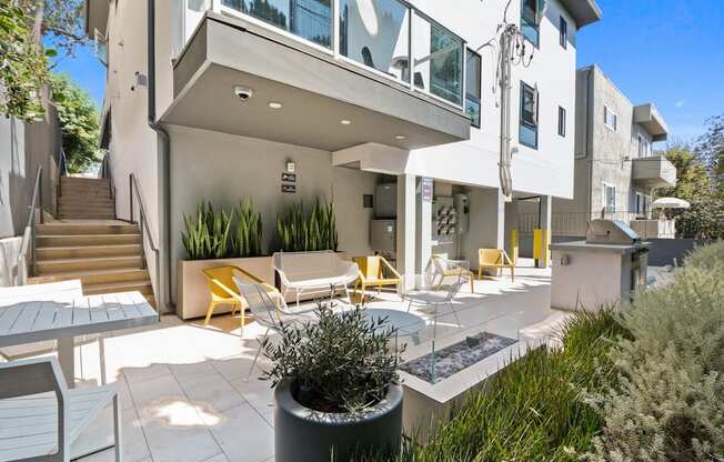 a patio with tables and chairs and a building with stairs