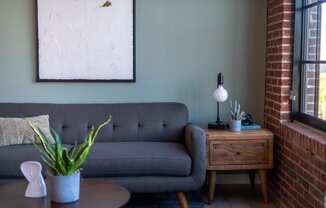 a living room with a gray couch and a wooden side table at The 22 Apartments, Missouri