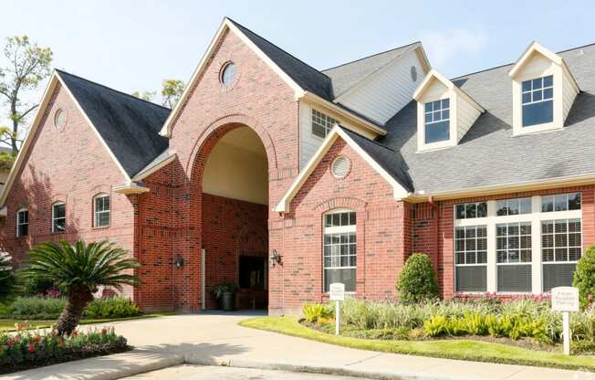 the front of a brick house with a driveway and a palm tree at Veranda at Centerfield, Houston, TX, 77070
