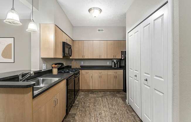 A kitchen with wooden cabinets and black countertops at Lynbrook Apartments and Townhomes, Elkhorn, NE, 68022