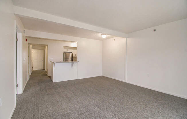 A living and dining room with a carpeted floor at West Hampton Park Apartments in Elkhorn, NE 68022