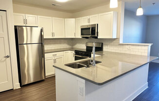 Modern kitchen with white shaker-style cabinets and stainless steel appliances  at Signature Pointe Apartment Homes, Athens, Alabama