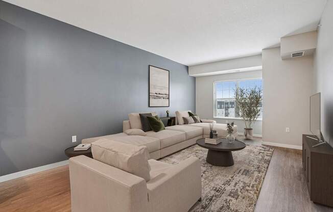 A living room with a grey wall and a white couch.