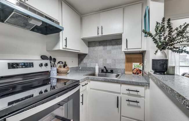 a kitchen with white cabinets and stainless steel appliances