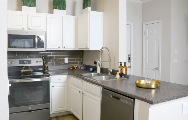 a kitchen with white cabinets and stainless steel appliances