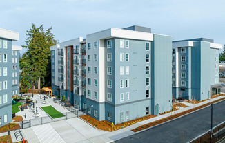 a rendering of a blue and gray apartment building with a sidewalk in front of it at QUINN BY VINTAGE, Shoreline, Washington