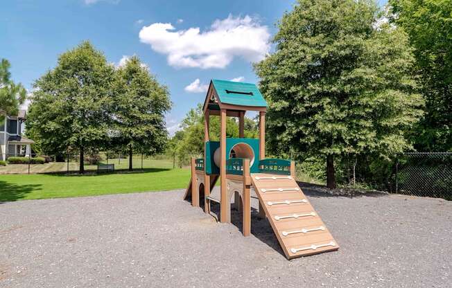 A playground with a green roof and a slide.
