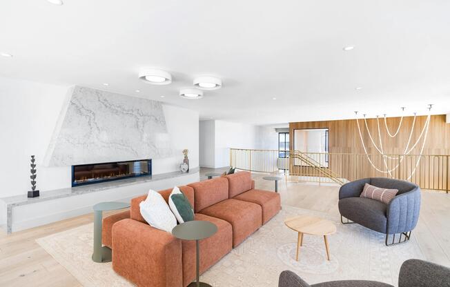 A light-filled resident lounge with statement fireplace, inviting seating, and space to relax or connect.