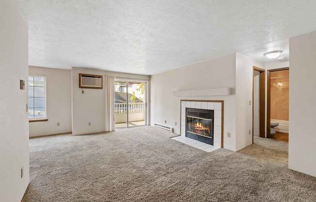 a living room with a fireplace and a door to a balcony