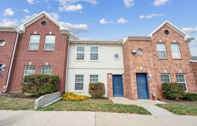 A red brick house with a white door and windows.