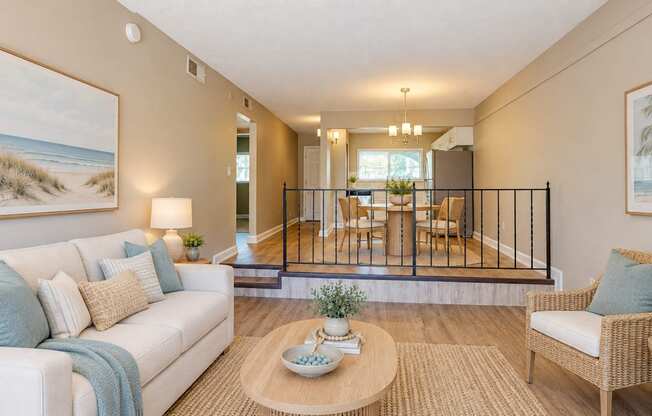 Virtually staged living room in the foreground and dining area behind it at Waterchase Apartments in Largo, FL.