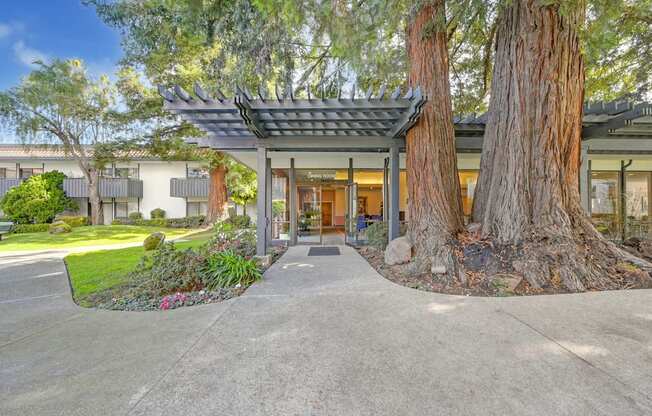 a building with trees in front of it and a driveway