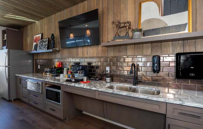 A modern kitchen with a wooden ceiling and a black fridge.