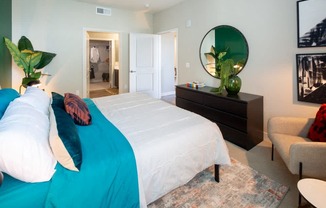A bedroom with a large bed and a mirror on the wall.