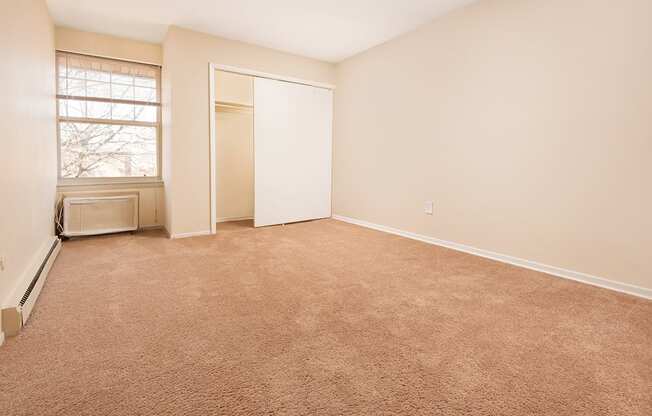 A room with a brown carpet and a window.