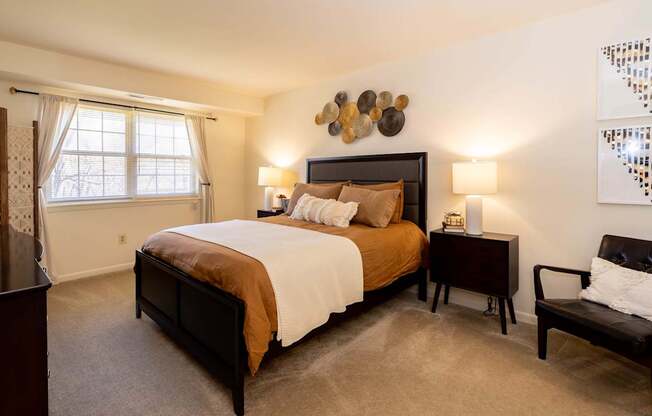 A bedroom with a large bed and a chair.