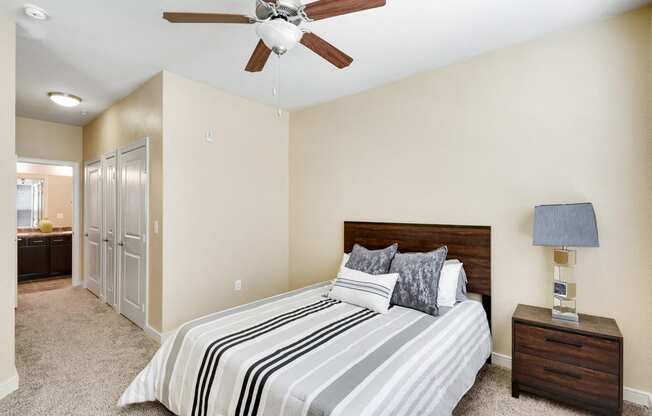 the master bedroom has a large bed and a ceiling fan
