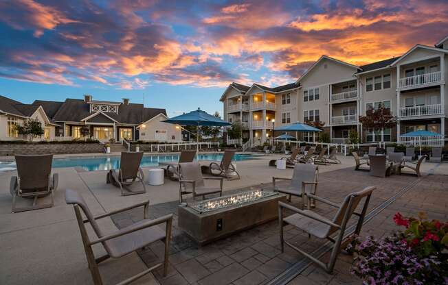 a swimming pool with chairs and umbrellas at dusk