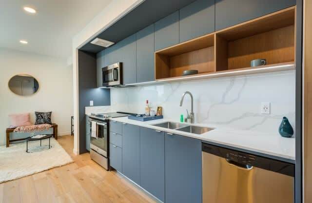 A modern kitchen with a stainless steel dishwasher and a marble backsplash.