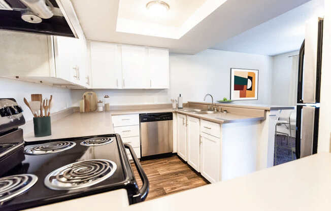 A modern kitchen with a stove top oven and white cabinets.