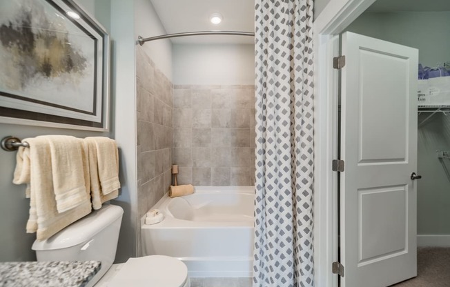 a bathroom with a tub and a toilet and a shower