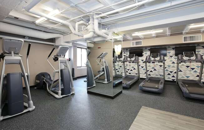 a spacious fitness center with treadmills and elliptical machines