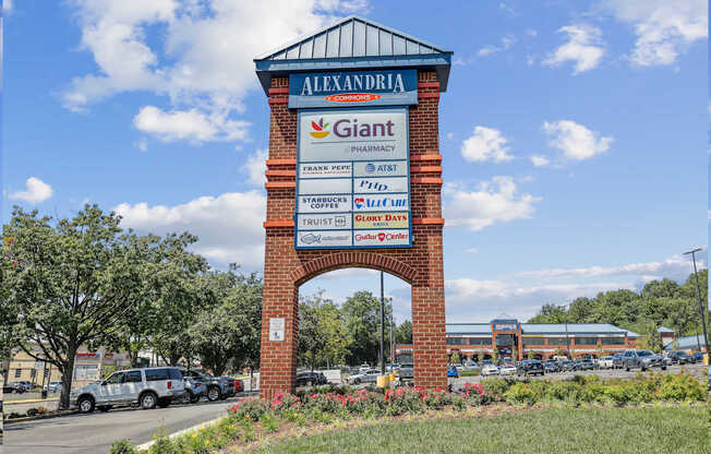 A brick sign for Giant Pharmacy is in front of a parking lot.